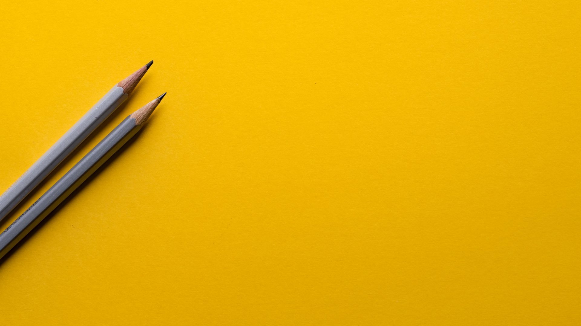 Two pencils on yellow ground